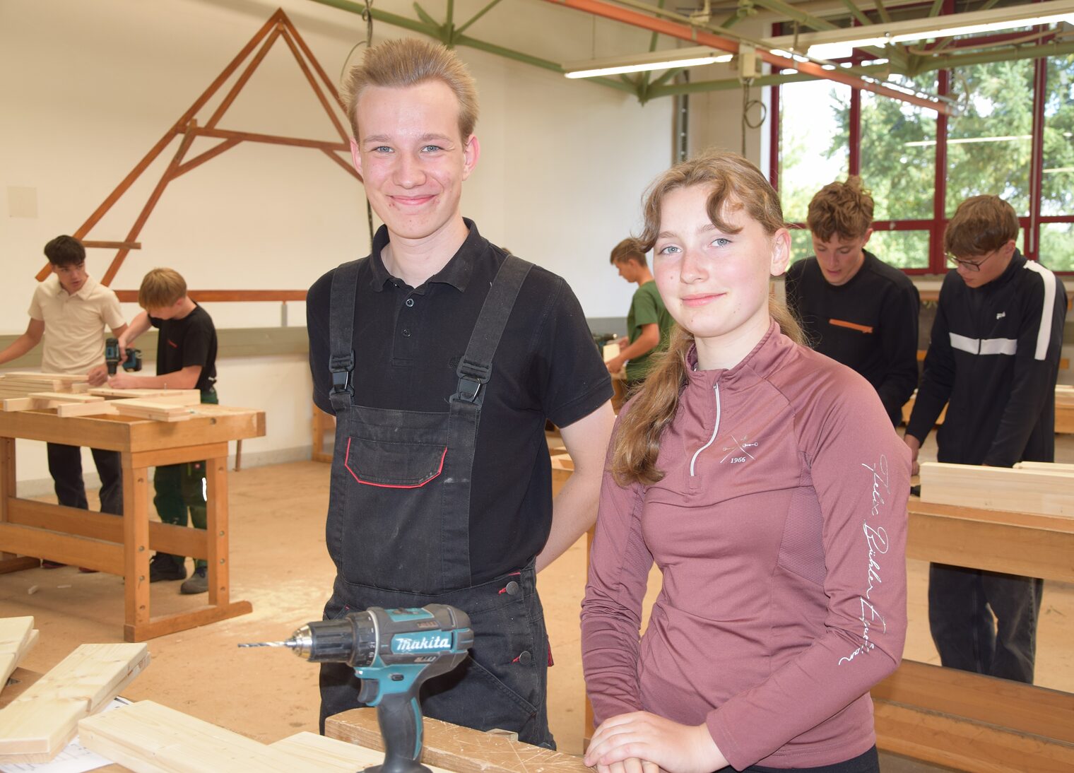 Alan und Lea lächelnd an einer Werkbank