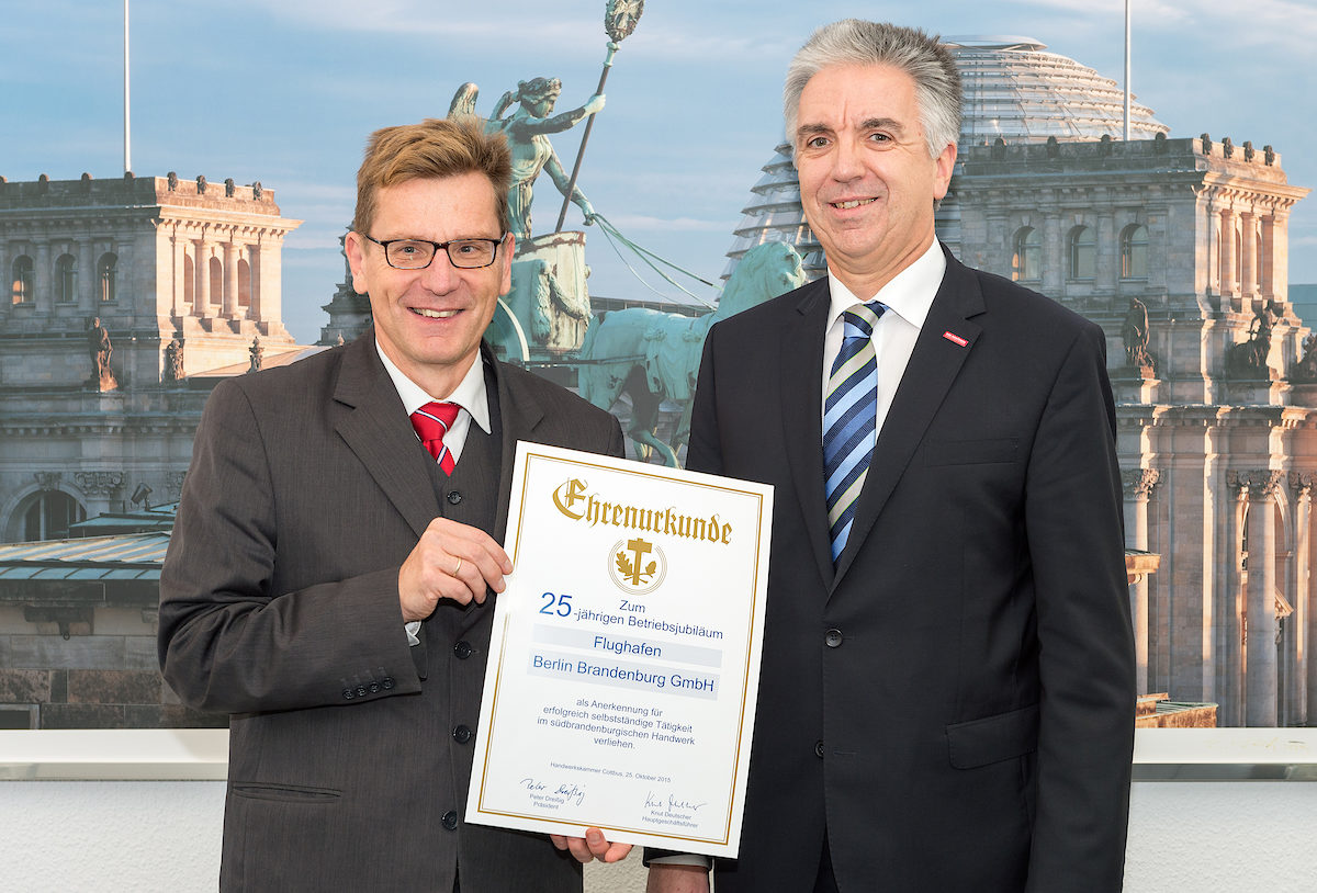 Hauptgeschäftsführer der Handwerkskammer Cottbus Knut Deutscher übergibt an den CEO der Flughafen Berkin Brandenburg GmbH eine Ehrenurkunde anläßlich des 25. Betriebsjubiläums am 19.11.2015 in Berlin-Schönefeld.