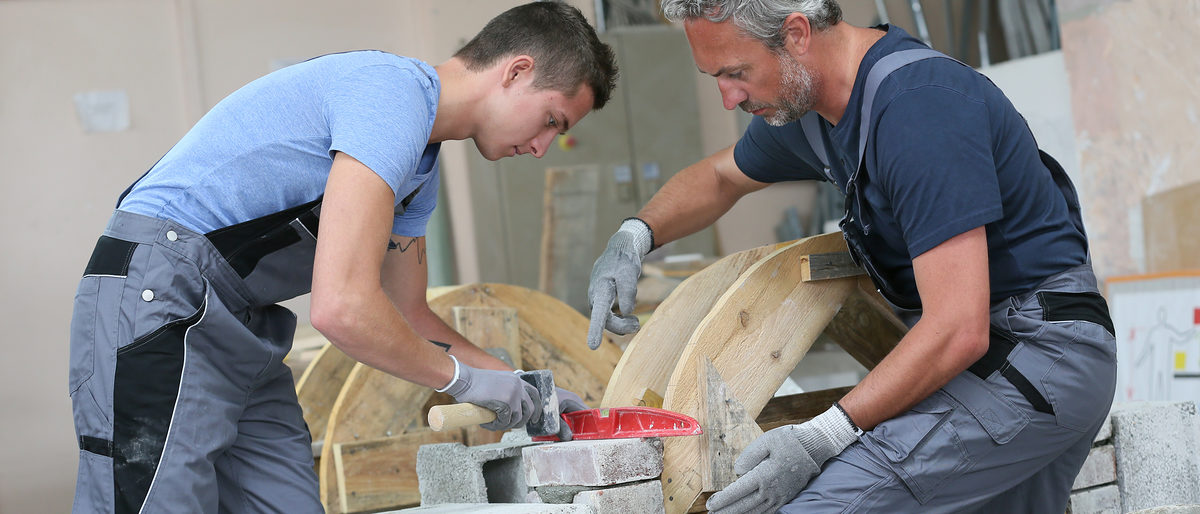 Teenager with professional brick layer in training school Ausbildung, maurer, mauern, praktikum, quer