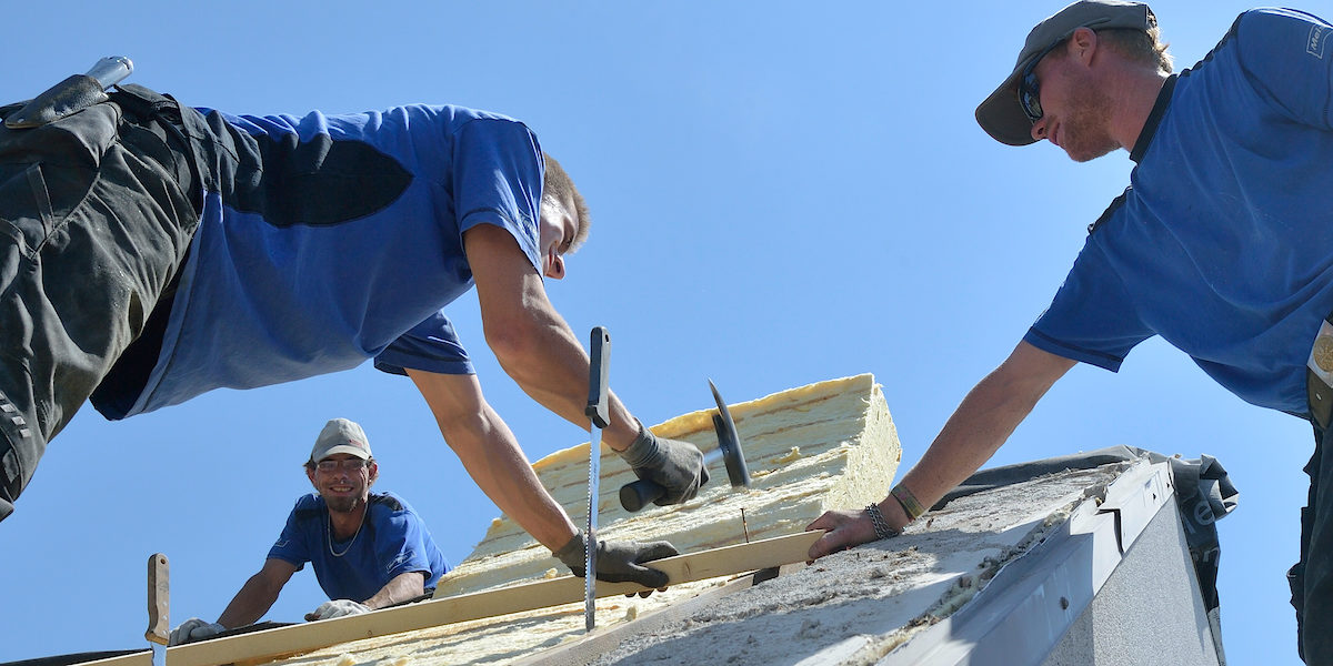 Dachdecker,Dach decken, Männer decken ein Dach,Handwerk,Meisterschule,Dämmung,Dämmen,Dachdämmung