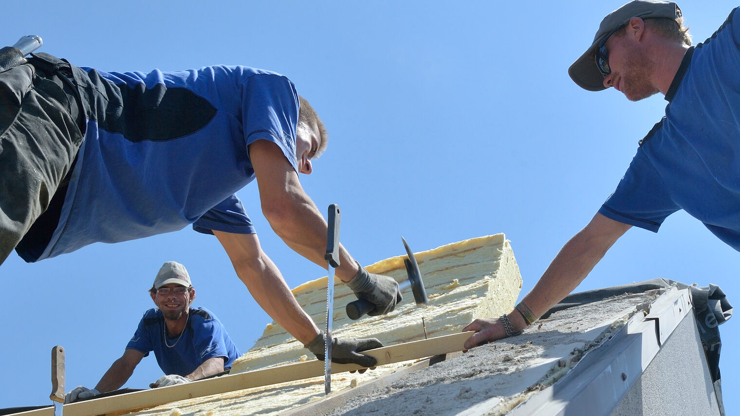 Dachdecker,Dach decken, Männer decken ein Dach,Handwerk,Meisterschule,Dämmung,Dämmen,Dachdämmung