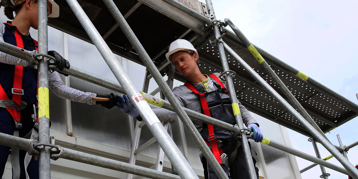 Gerüstbua,Gerüstbau Ausbildung,Gerüstbau Meisterschule,Handwerk,Gerüstbauer,Gerüstbauerin,Frau Gerüstbau,Mehrere Personen bauen ein Gerüst