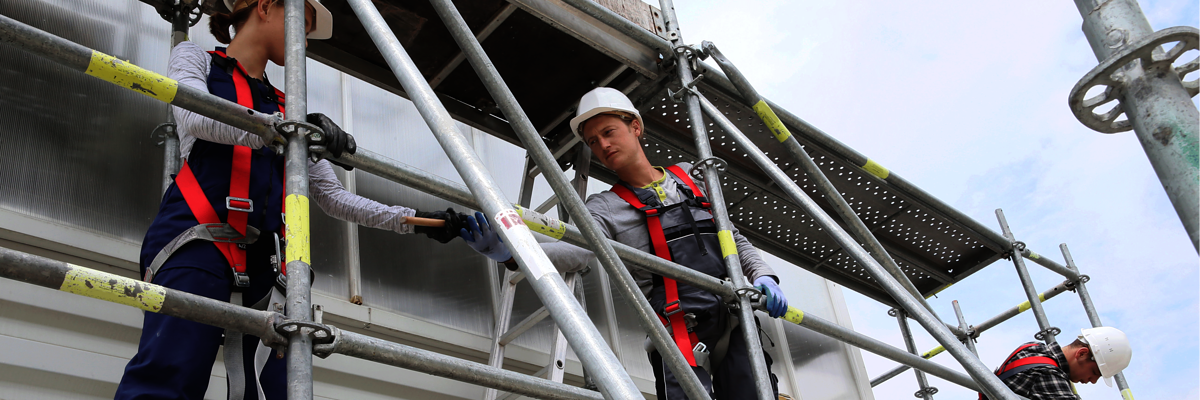 Gerüstbua,Gerüstbau Ausbildung,Gerüstbau Meisterschule,Handwerk,Gerüstbauer,Gerüstbauerin,Frau Gerüstbau,Mehrere Personen bauen ein Gerüst