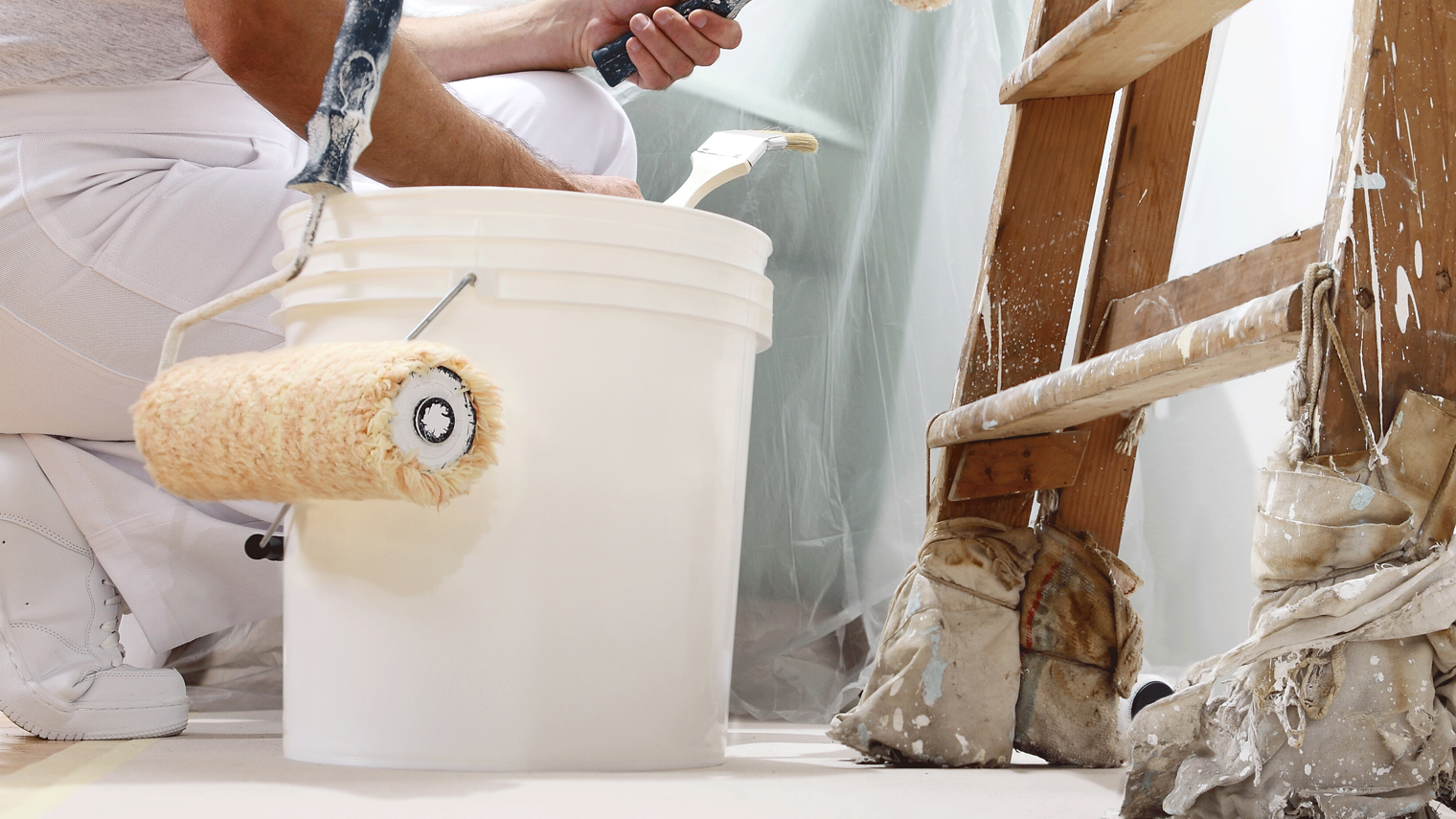 Maler,Lackierer,Maler und Lackierer,Malermeister,Maler und Lackierer Meisterschule,Handwerk,Meisterschule,Malerhandwerk,meisterausbildung Maler und Lackierer,Maler hockt vor einer Leiter und streicht eine Wand