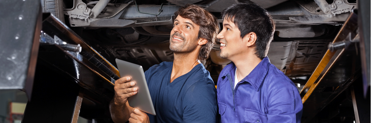 Ausbilder und Lehrling stehen unter einem Auto,Ausbildung,Lehrstelle,Kfz,Kfz Mechatroniker