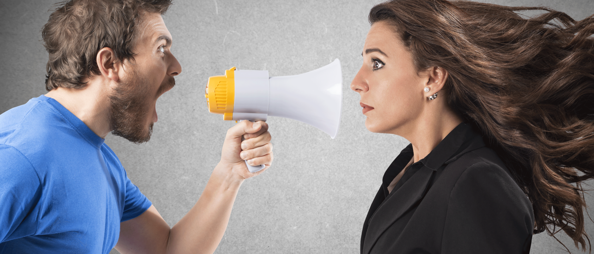 Mann schreit Frau mit einen Megaphone an,Konflikt,Konfliktmanagement