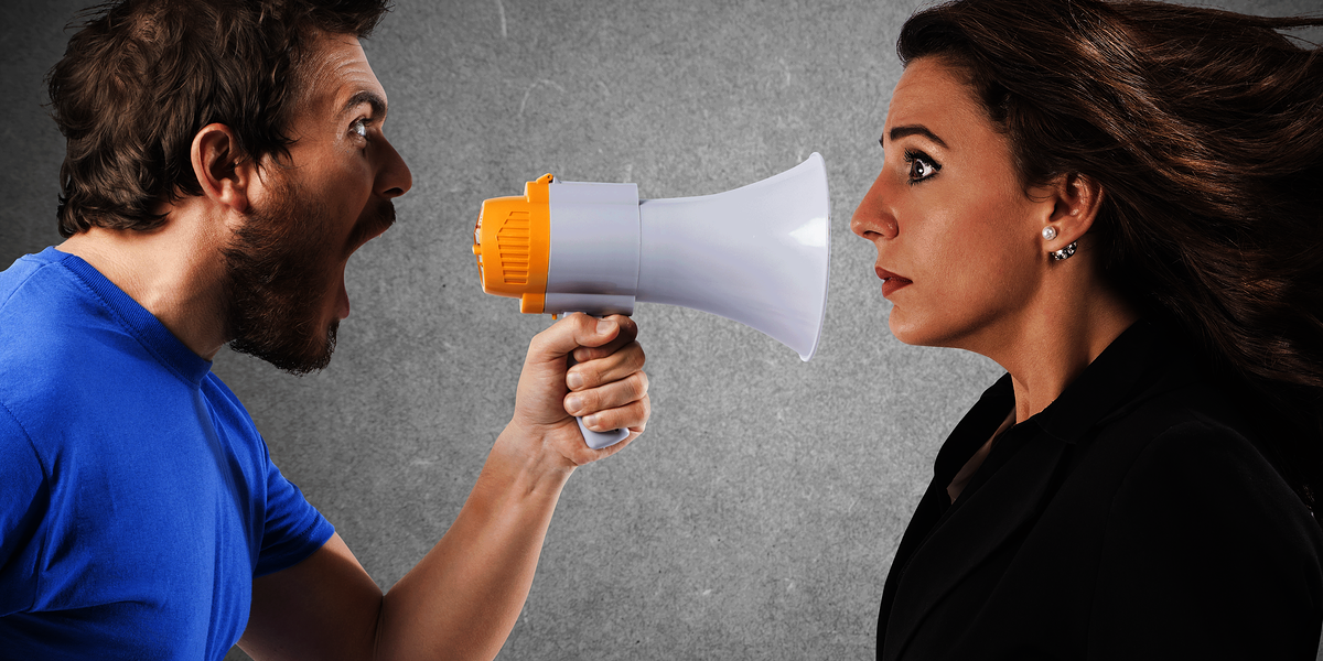 Mann schreit Frau mit einen Megaphone an,Konflikt,Konfliktmanagement