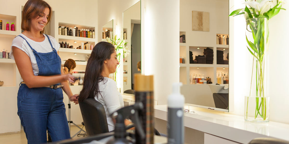 Friseur berät Kundin in einem Friseursalon.